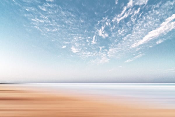 Sand beach shoreline underneath the blue sky